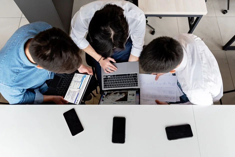 Top view of diverse colleagues in a business meeting discussing strategies with charts and laptops.